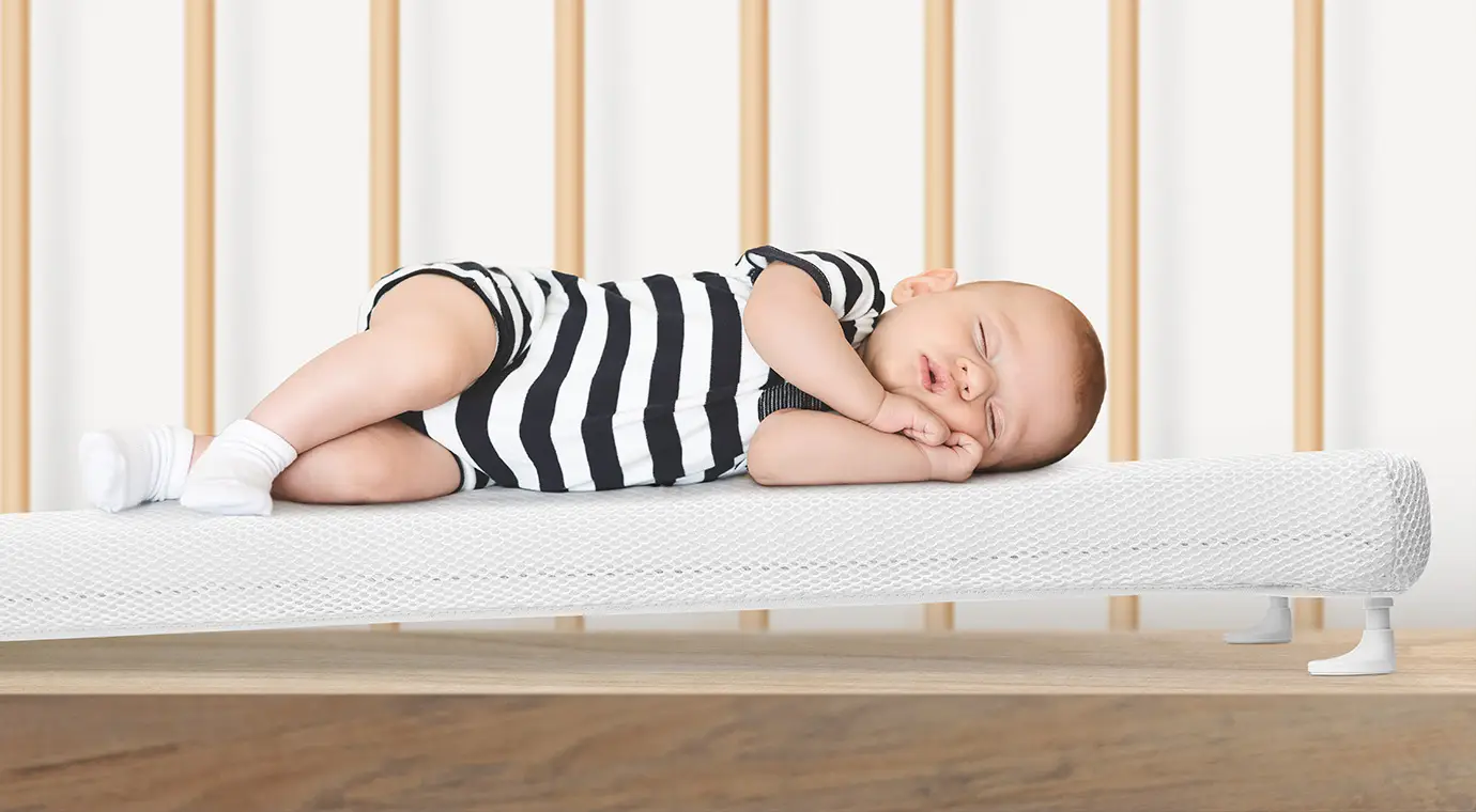 baby sleeping on side on elevated numu air best infant mattress