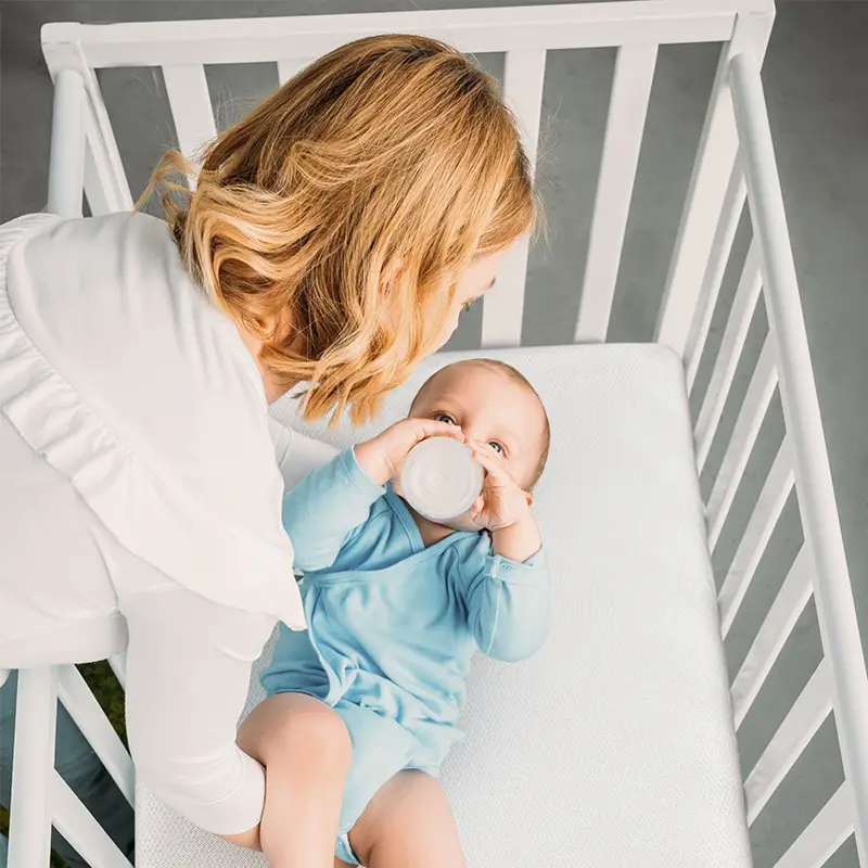 mother putting baby onto numu air best breathable crib mattress