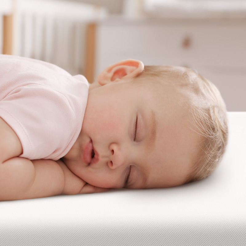 face of prone baby sleeping on numu air safest crib mattress